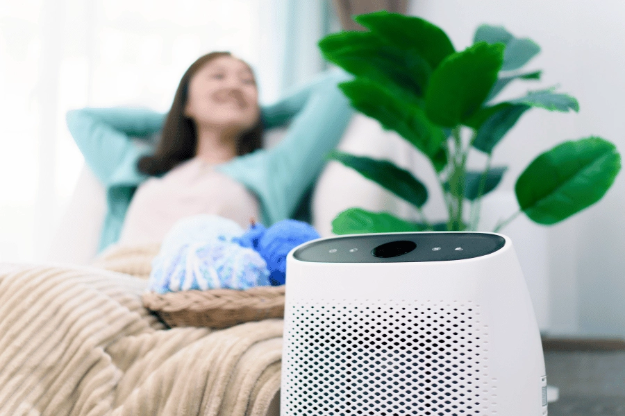 woman sitting in a room at home next to an air purifier